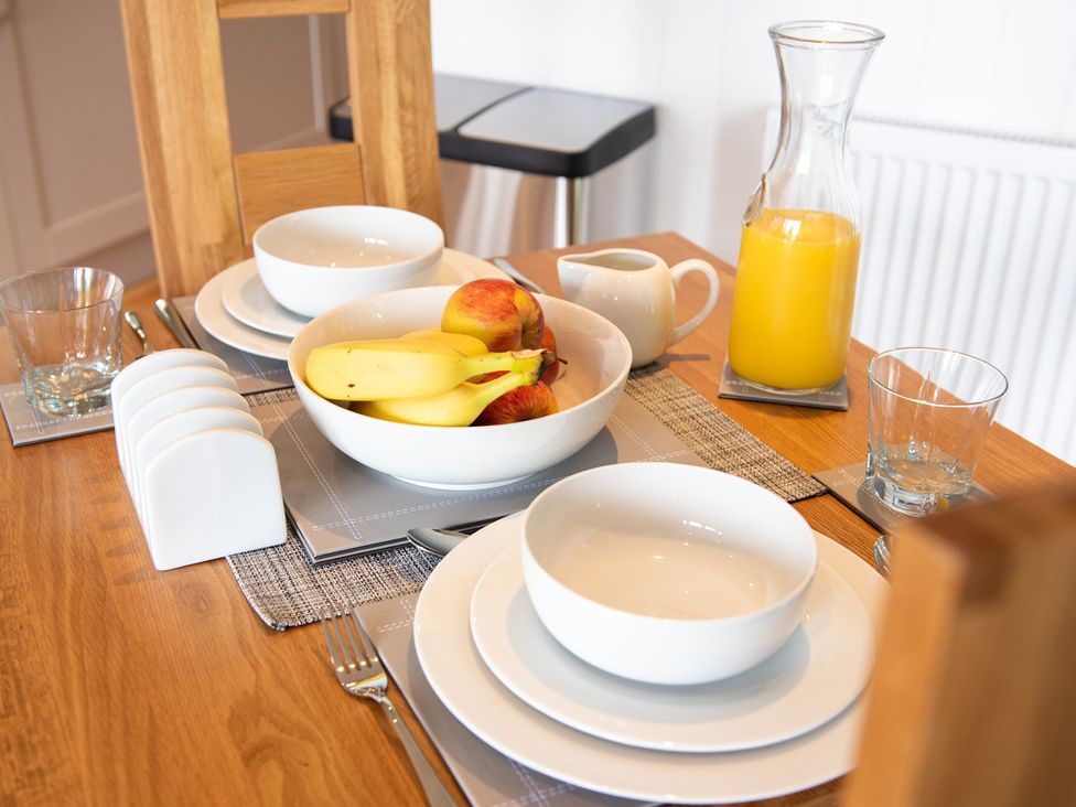 A dining table set with bowls and fruit at Nethermill Lodges in Port Glasgow