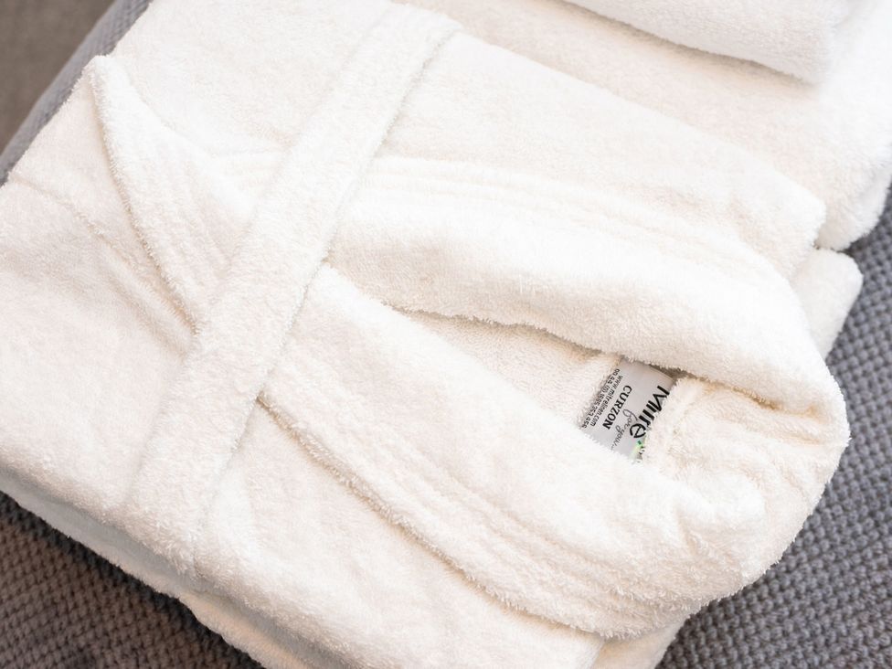 A folded bathrobe and towel at Nethermill Lodges in Port Glasgow