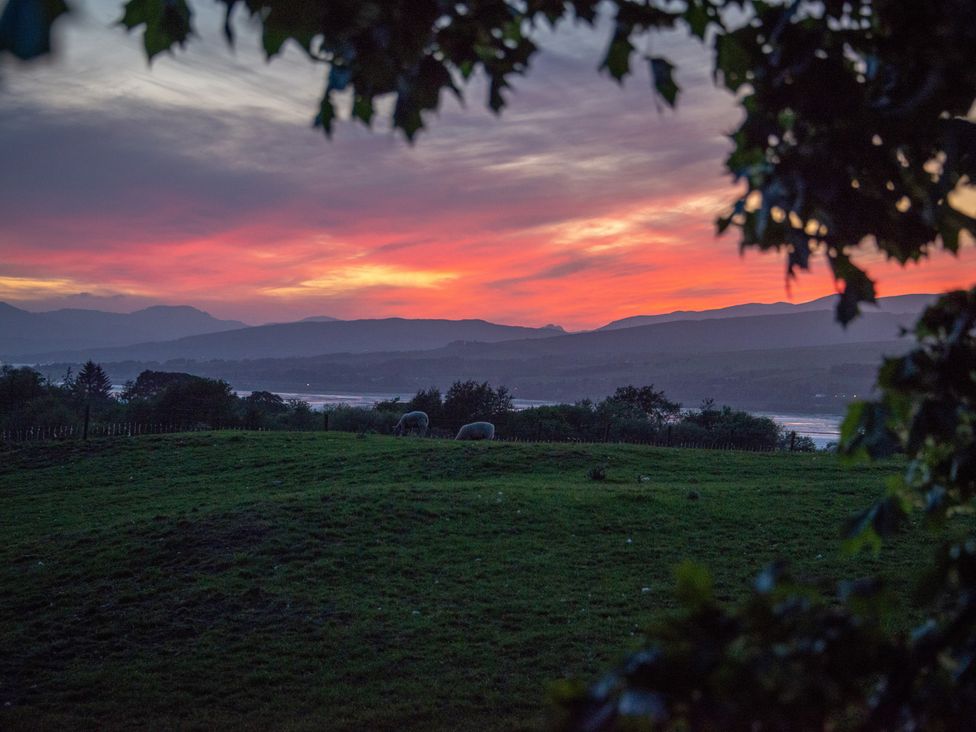 A sunset over hills with sheep grazing at Nethermill Lodges in Port Glasgow