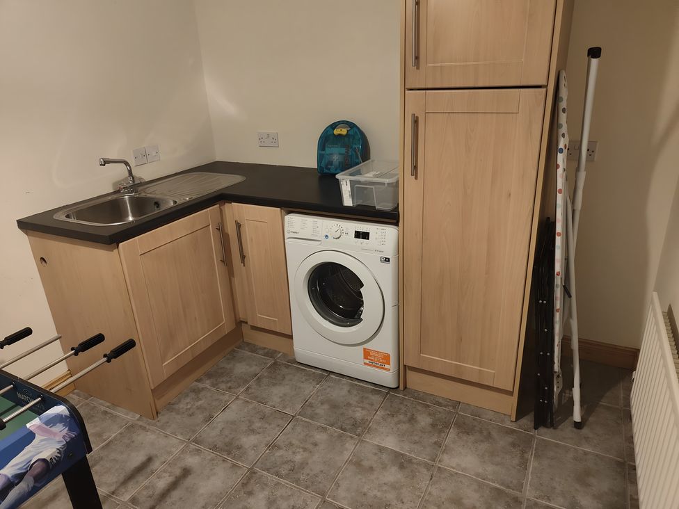 A laundry room with a washing machine and sink at 17 Castleview in Ballymena