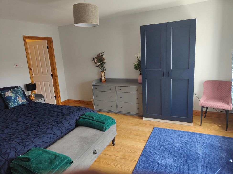 A bedroom with a bed, dresser, and wardrobe at 17 Castleview in Ballymena