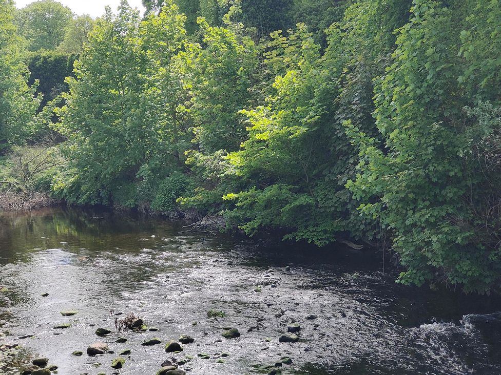 A river with trees and rocks along the bank at 17 Castleview in Ballymena