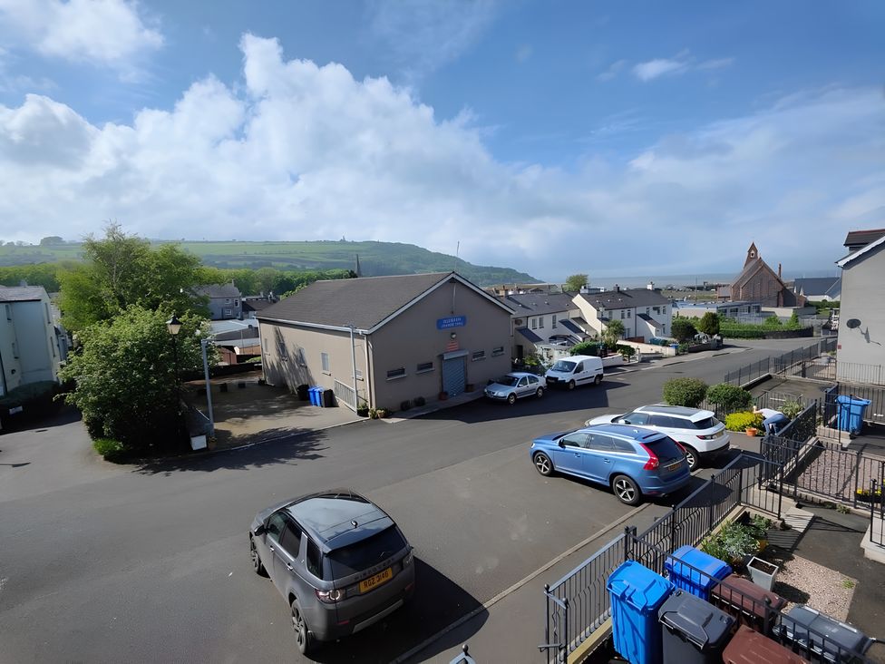 A street view with buildings and parked cars at 17 Castleview in Ballymena