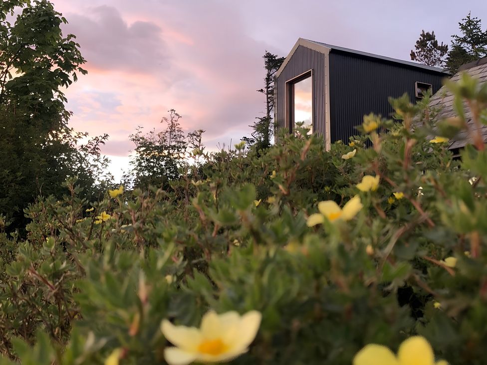 A building with a window surrounded by plants and flowers at Cullinview Isle of Skye