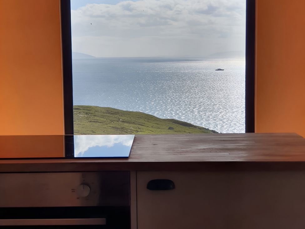 A kitchen with a view of the sea and hills at Cullinview Isle of Skye