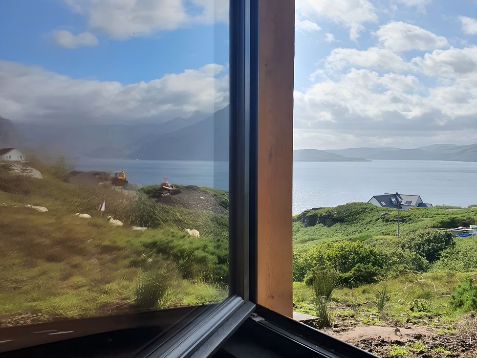 A view of water and mountains through a window at Cullinview in Isle of Skye