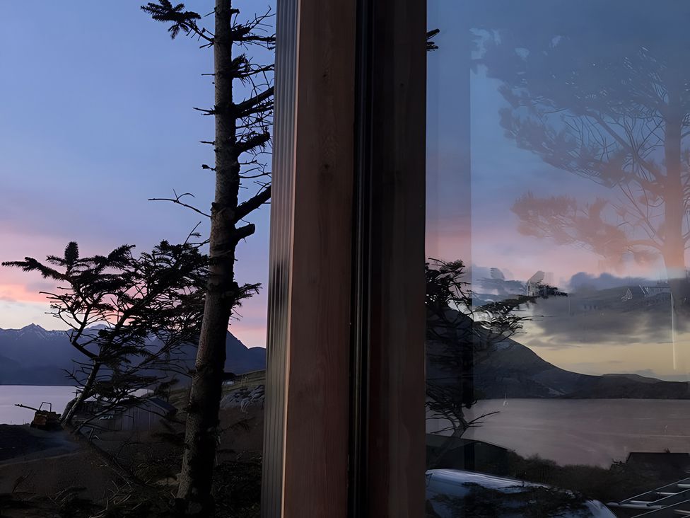 A view of mountains and water through a window at Cullinview Isle of Skye