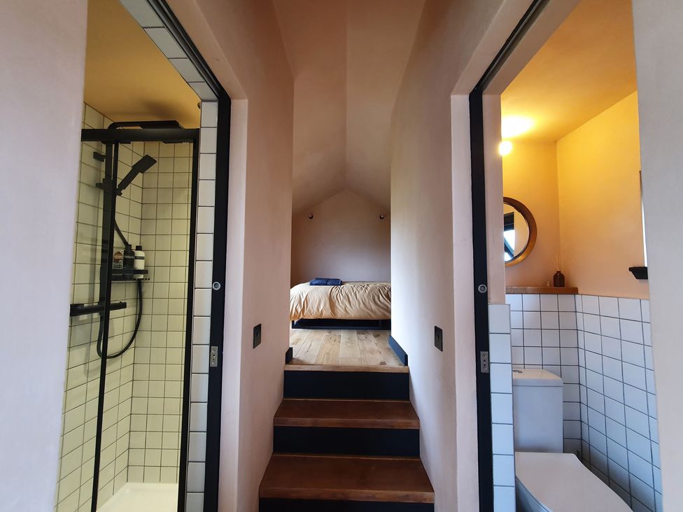 A bedroom with a bed and staircase at Cullinview in Isle of Skye