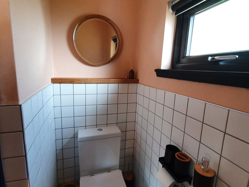 A bathroom with a toilet and mirror at Cullinview in Isle of Skye