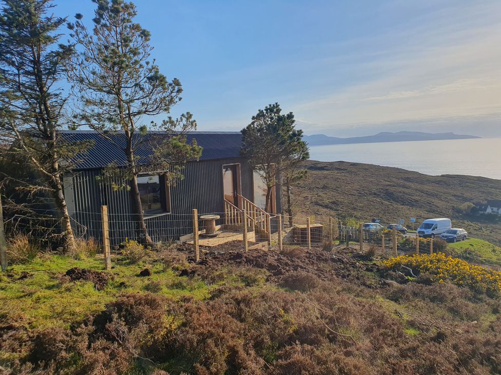 A house with a fence and trees overlooking the water at Cullinview Isle of Skye