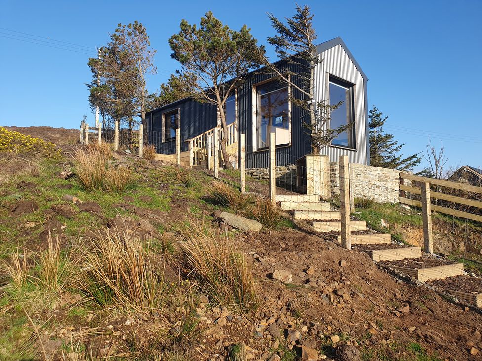 A house with stairs and a fence on a hillside at Cullinview Isle of Skye