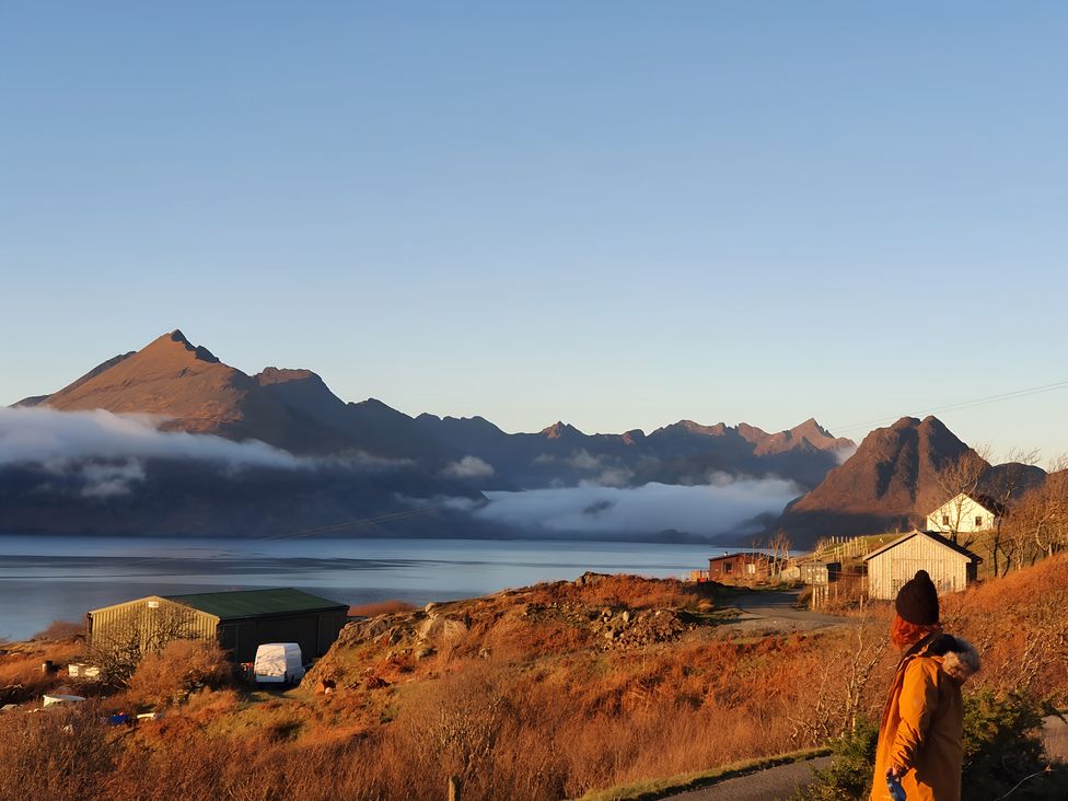 A view of mountains and lake with a person near houses at Cullinview Isle of Skye