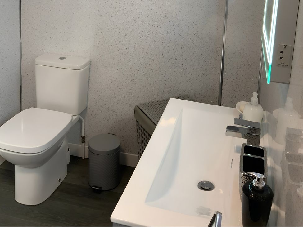 A bathroom with a toilet and sink at Fenton Drive in Wooler