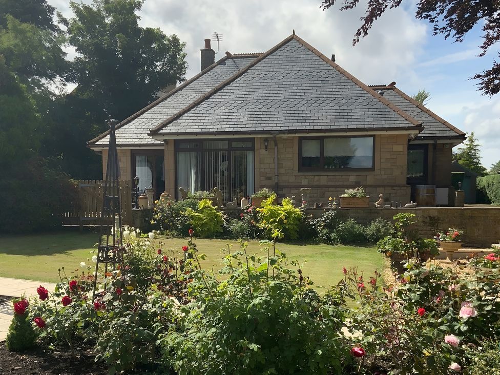 A house with a garden and flowers at Fenton Drive in Wooler