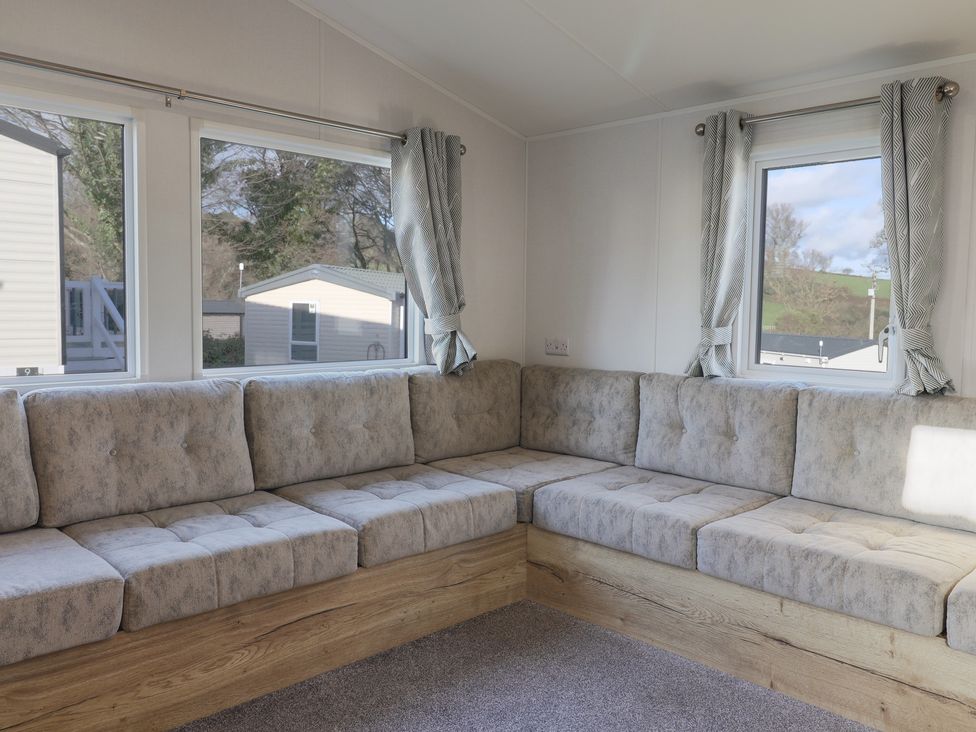 A snug area with a corner sofa and windows at WF32 - Jurassic Discovery in Charmouth