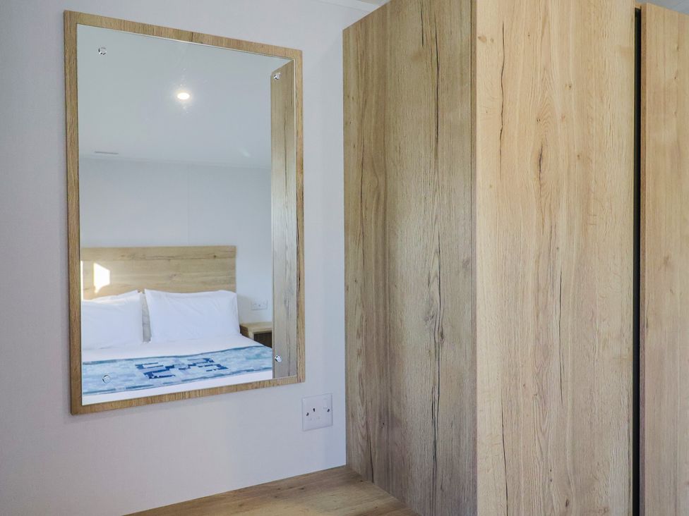 A bedroom with a mirror and a view of a bed at WF32 - Jurassic Discovery in Charmouth