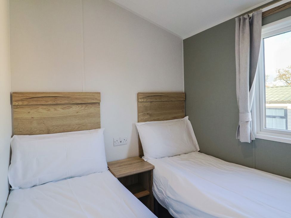 A bedroom with two single beds and a window at WF32 - Jurassic Discovery, Charmouth