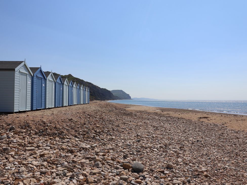 A row of beach huts by the sea at WF32 - Jurassic Discovery, Charmouth
