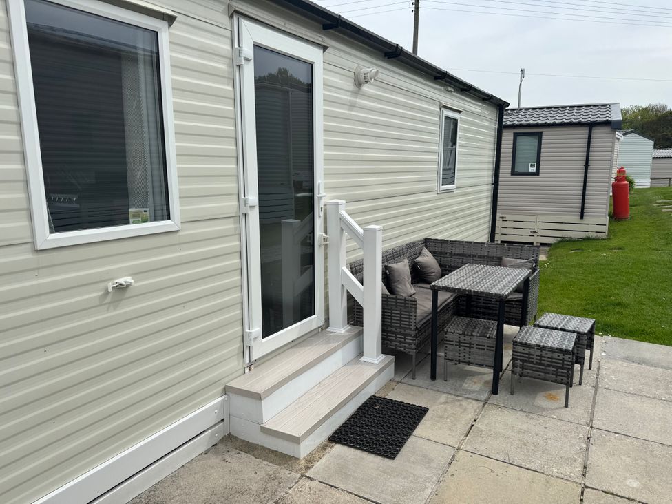 An outdoor seating area with a table and chairs at Jurassic Discovery in Charmouth