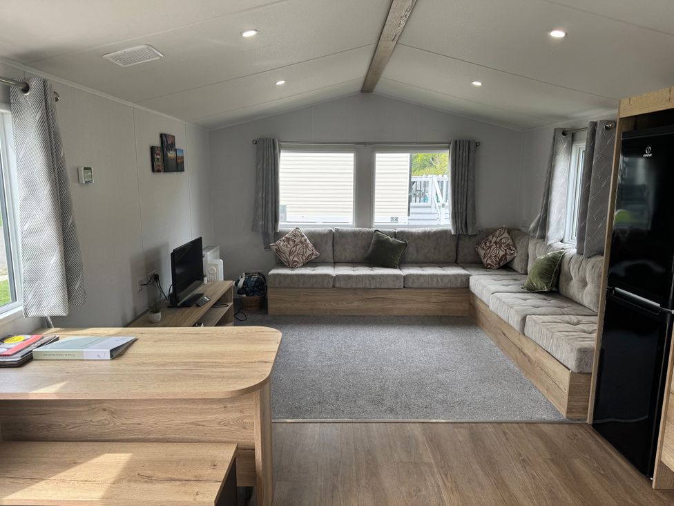 A living room with a sofa and television at Jurassic Discovery in Charmouth