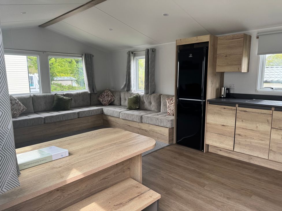 A living room with a sofa and refrigerator at Jurassic Discovery in Charmouth