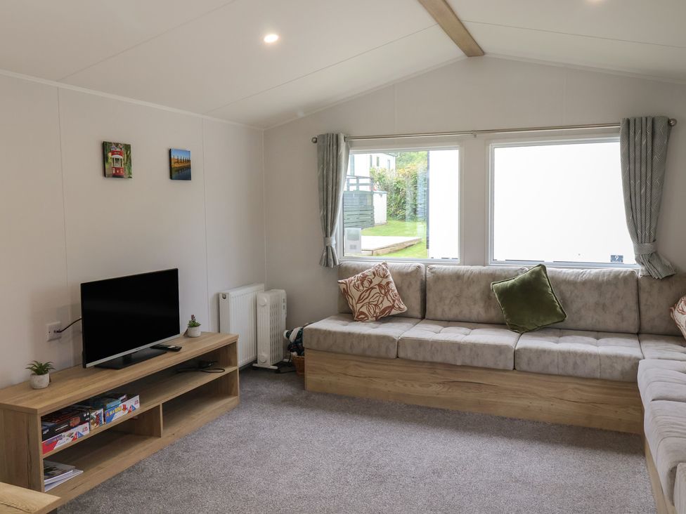 A living room with a sofa and television at Jurassic Discovery in Charmouth