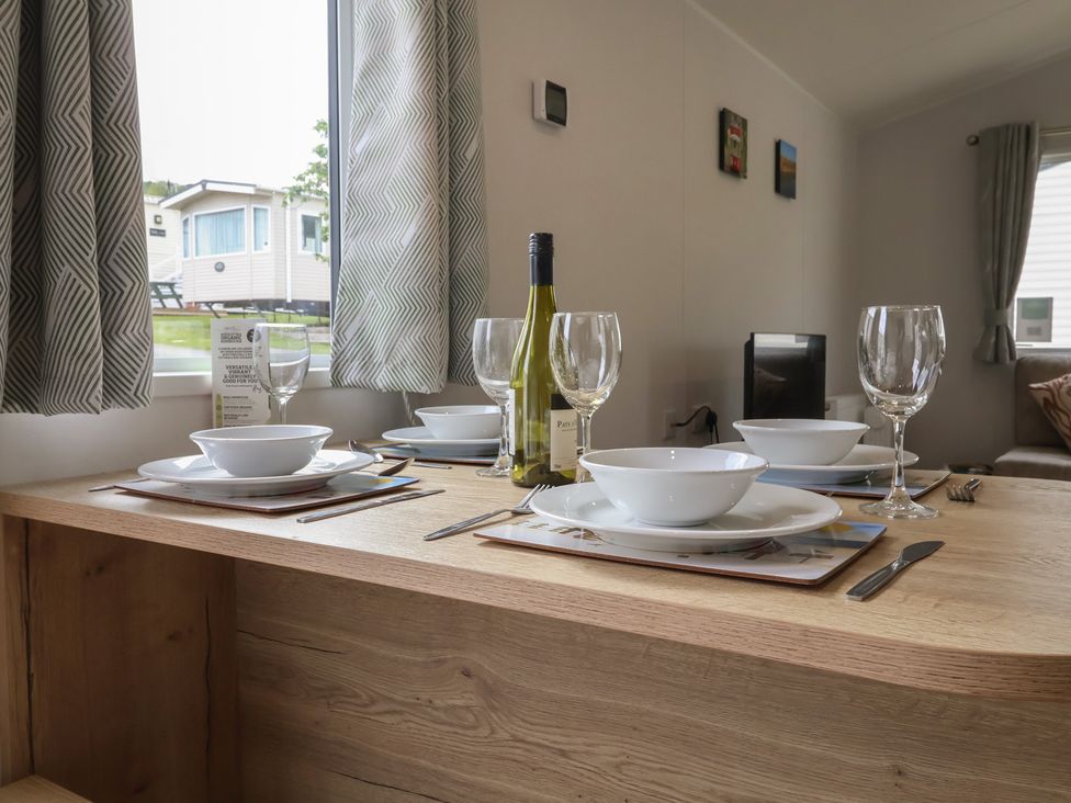A dining table set with plates and glasses at Jurassic Discovery in Charmouth