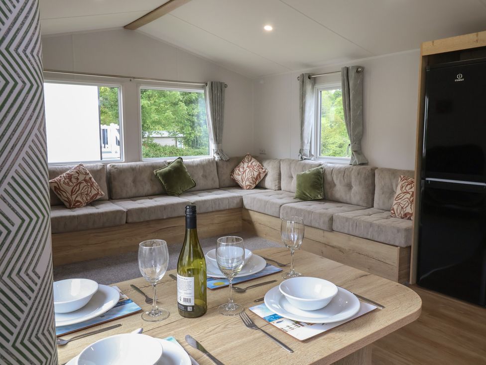 A living room with dining table and sofa at Jurassic Discovery in Charmouth