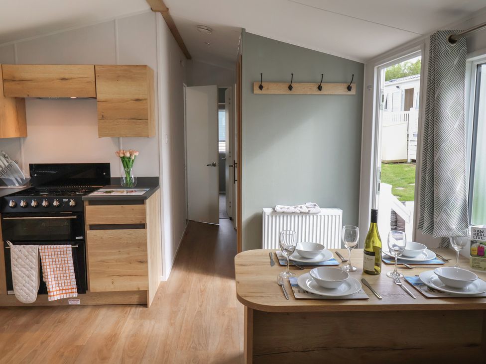 A kitchen with dining table and appliances at Jurassic Discovery in Charmouth