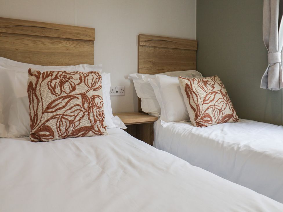 A bedroom with two beds and decorative pillows at Jurassic Discovery in Charmouth