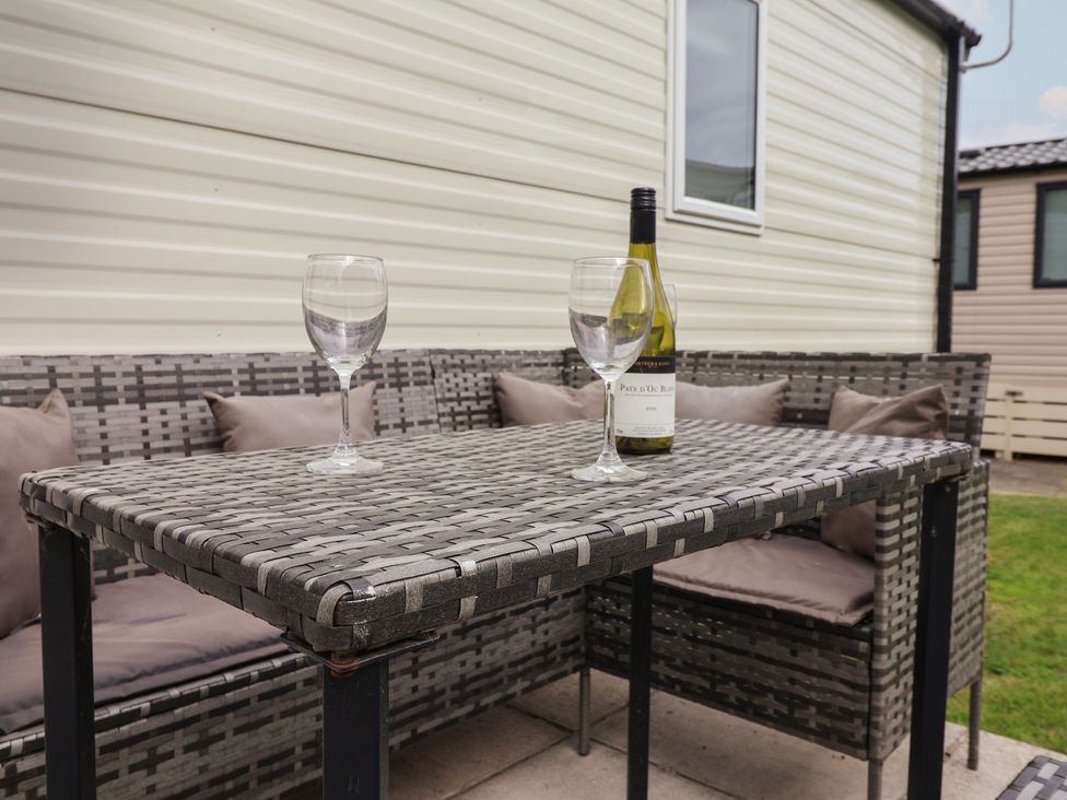 An outdoor seating area with a table and wine on display at Jurassic Discovery in Charmouth