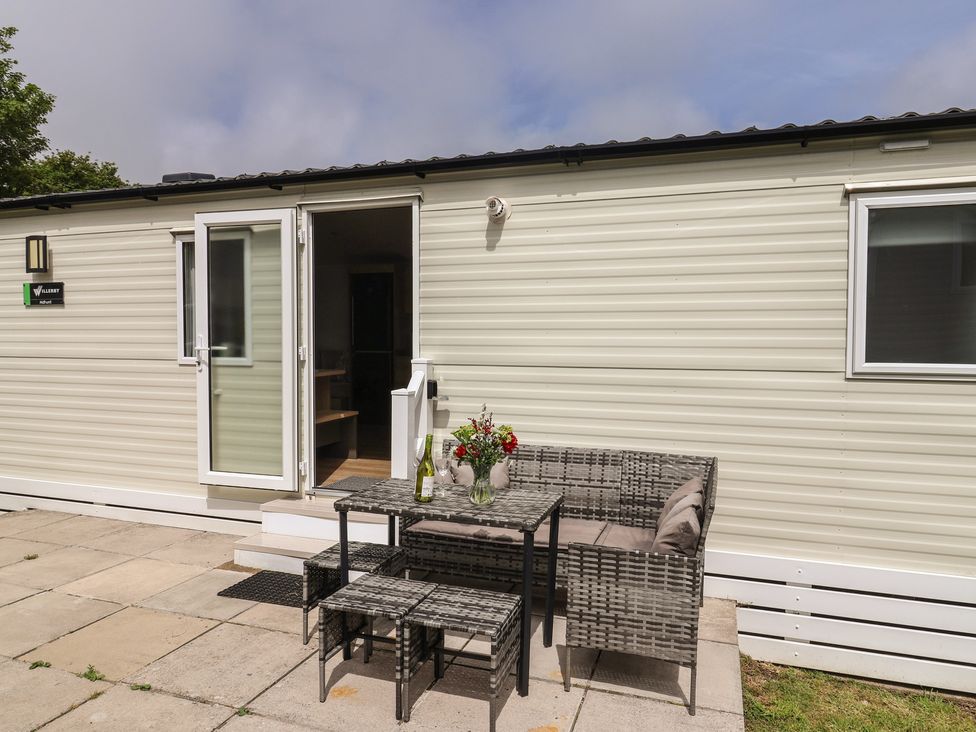 An outdoor patio with seating and flowers at Jurassic Discovery in Charmouth