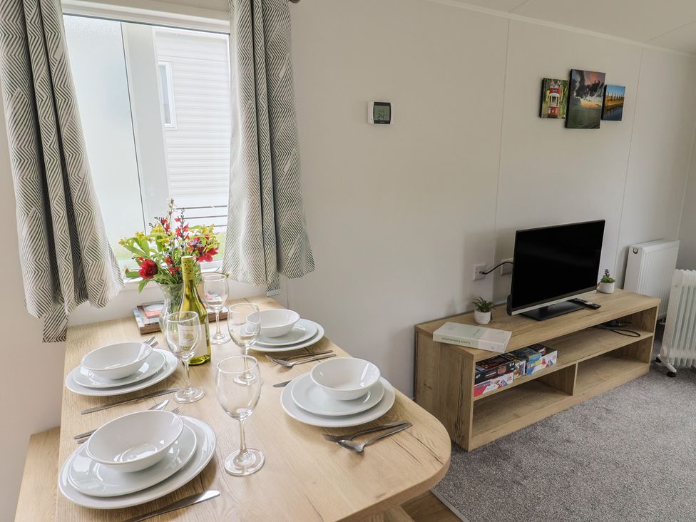 A dining area with a table set for meals at Jurassic Discovery in Charmouth