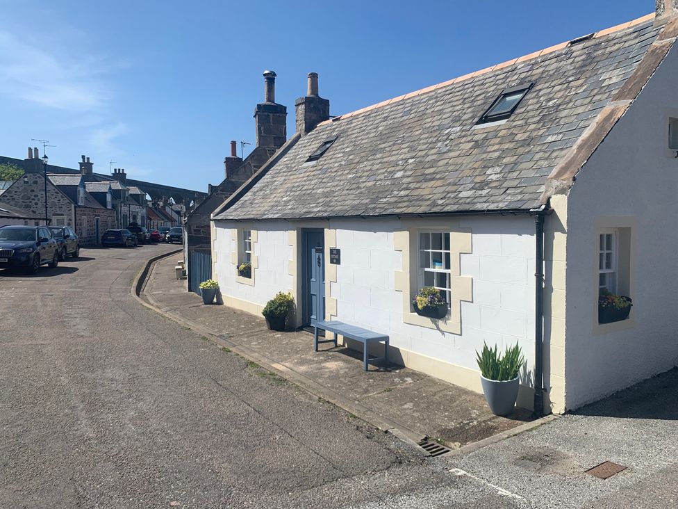A house with a bench in front and planters at Zen Cottage in Buckie