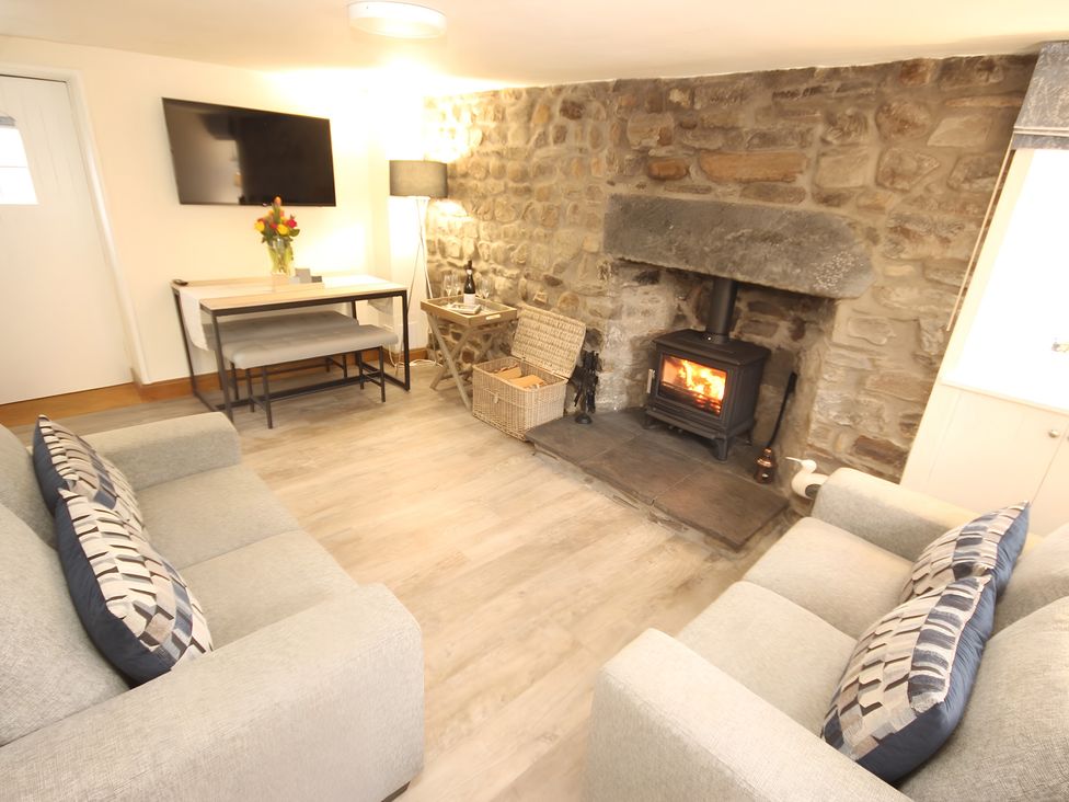 A living room with a fireplace and sofa at Zen Cottage in Buckie