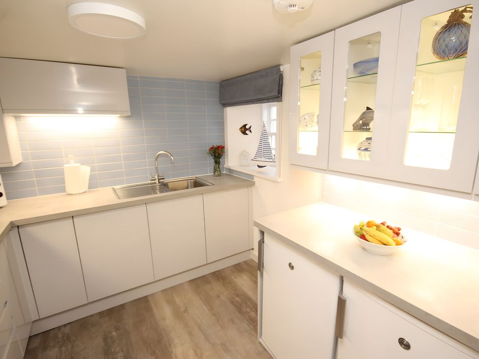 A kitchen with a sink and cabinets at Zen Cottage in Buckie