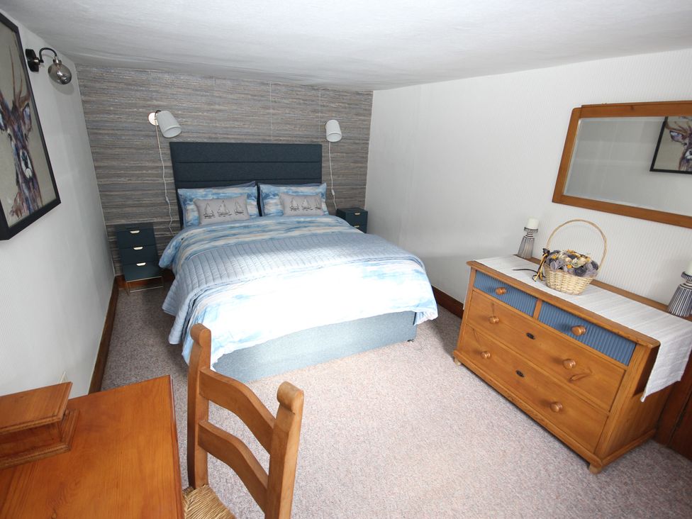A bedroom with a bed and dresser at Zen Cottage, Buckie