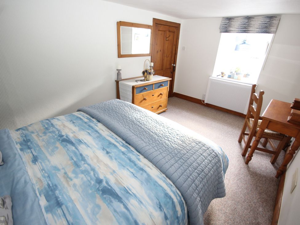 A bedroom with a bed and a dresser at Zen Cottage in Buckie