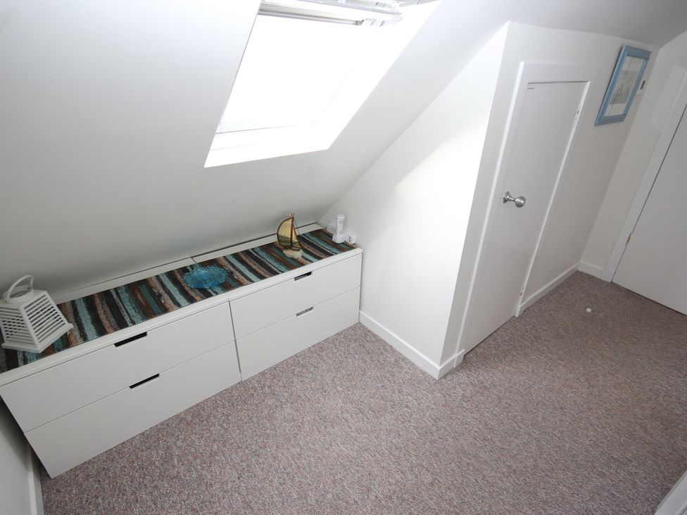 An attic with a drawer unit and decorative items at Zen Cottage in Buckie