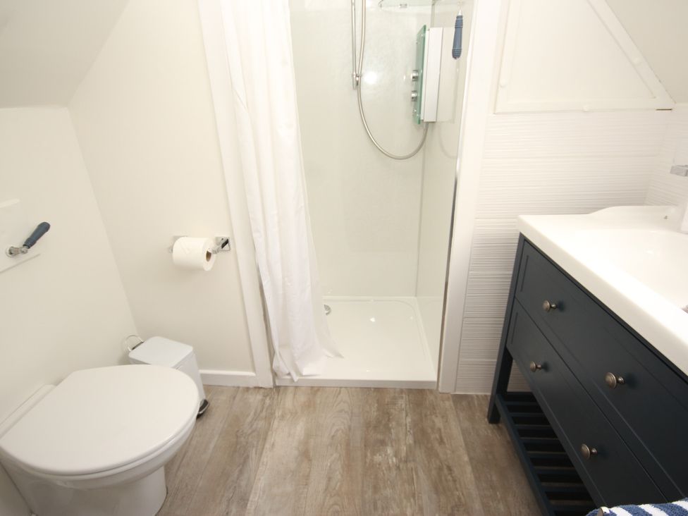 A bathroom with a shower and sink at Zen Cottage in Buckie