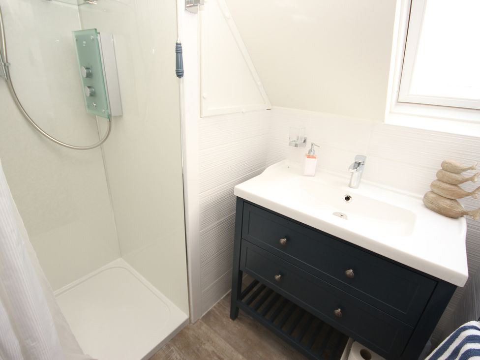 A bathroom with a shower and a vanity at Zen Cottage in Buckie