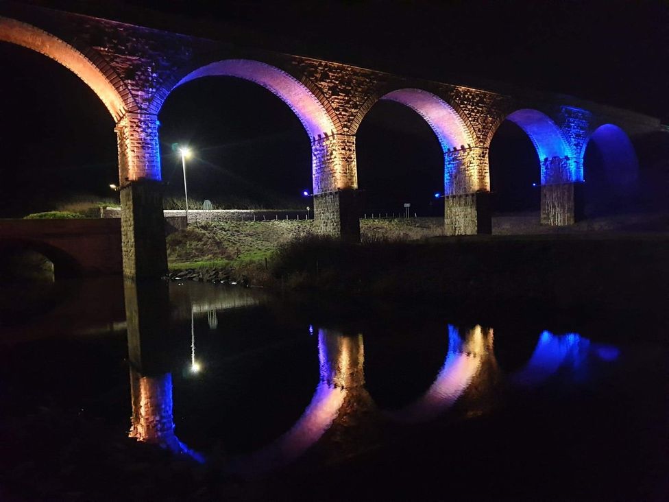 A illuminated bridge over a river at Zen Cottage in Buckie