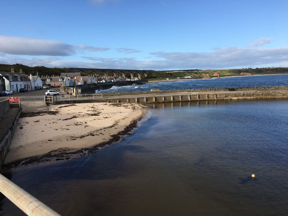 A view of the sea and houses by the shore at Zen Cottage in Buckie