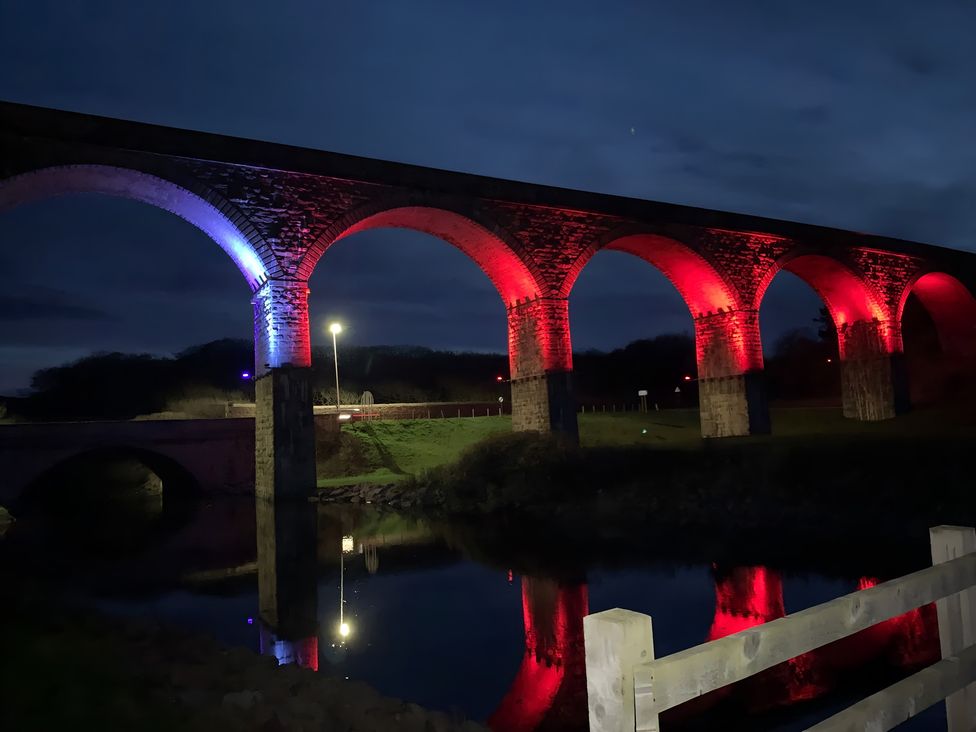 A bridge illuminated with lights over a river at Zen Cottage in Buckie