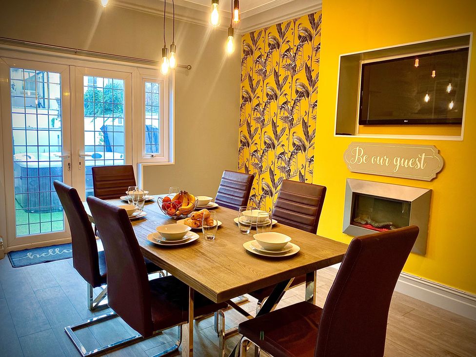 A dining room with a table set for meal and a television at 1 Horncliffe Road Blackpool