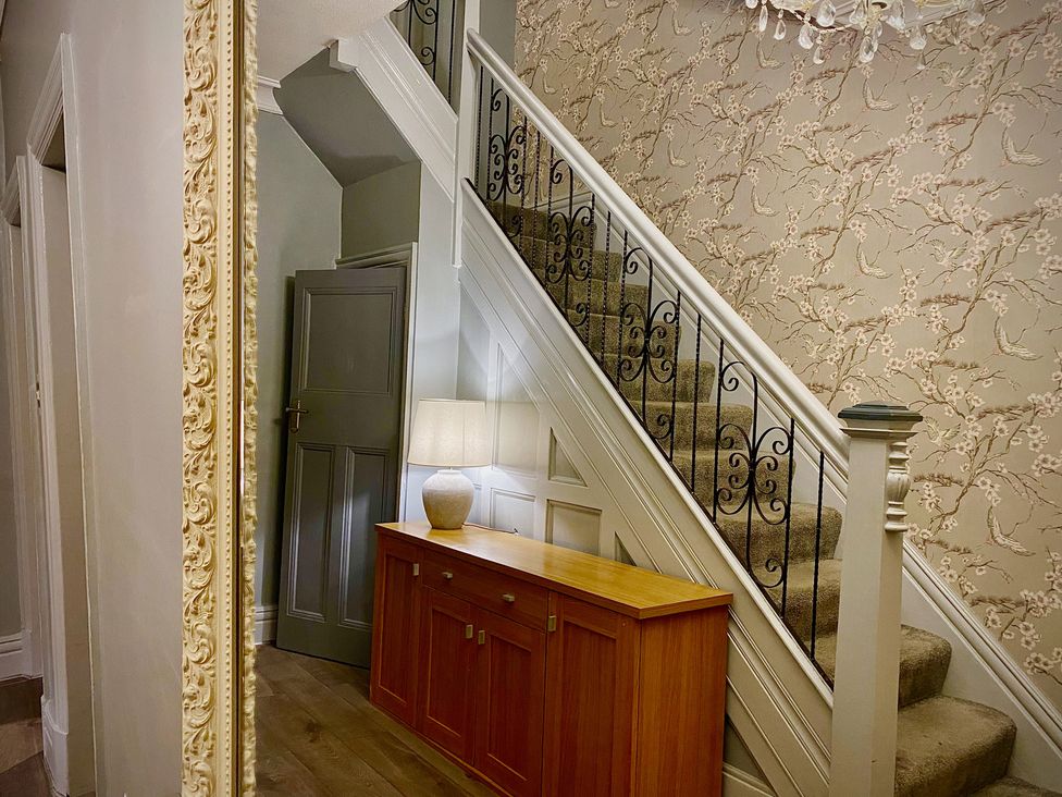 A hallway with a staircase and a table at 1 Horncliffe Road Blackpool