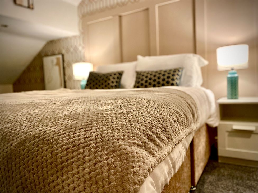 A bedroom featuring a bed with pillows and a bedside lamp at 1 Horncliffe Road Blackpool