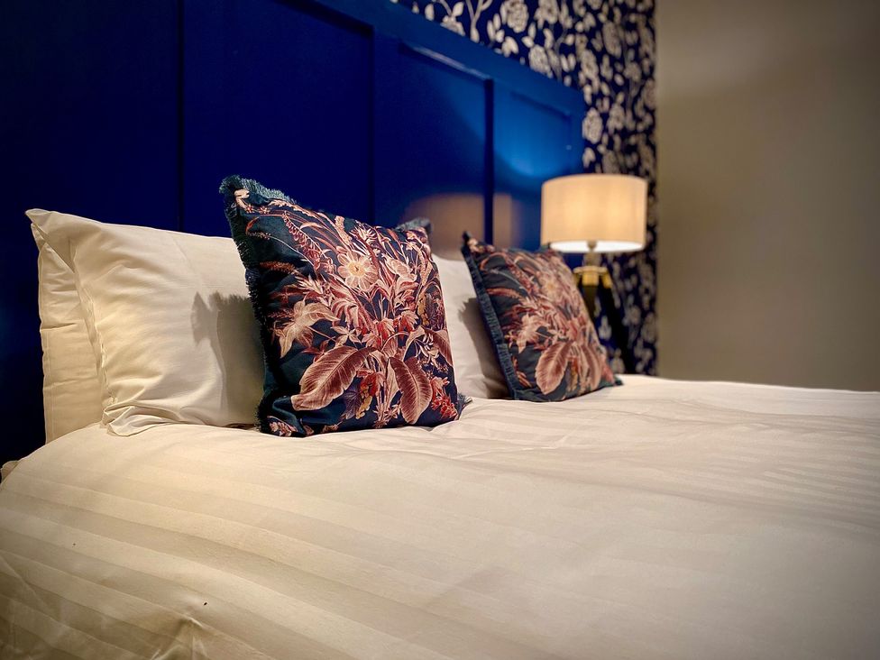 A bed with pillows and a lamp at 1 Horncliffe Road, Blackpool