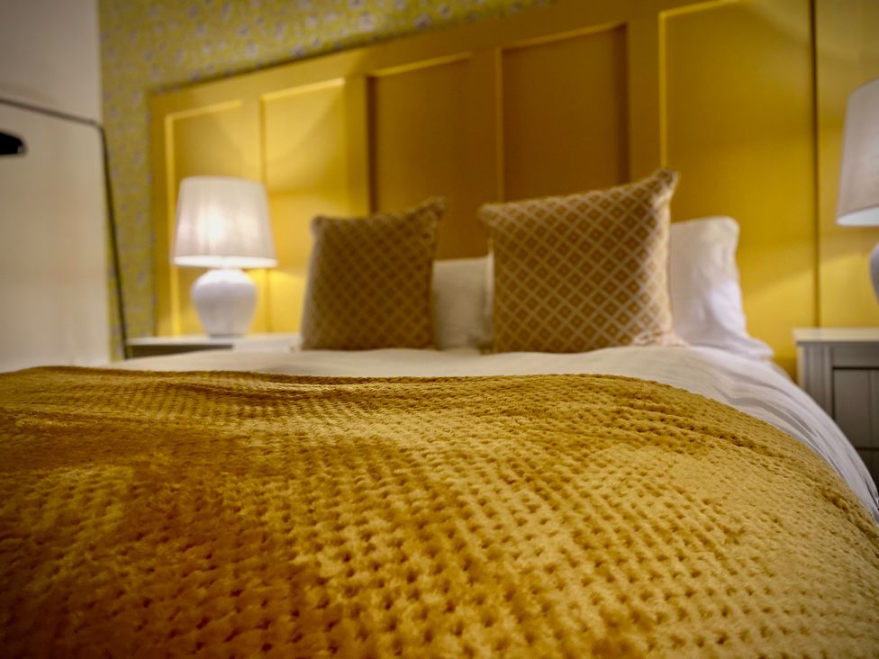 A bedroom with a bed and yellow blanket at 1 Horncliffe Road Blackpool