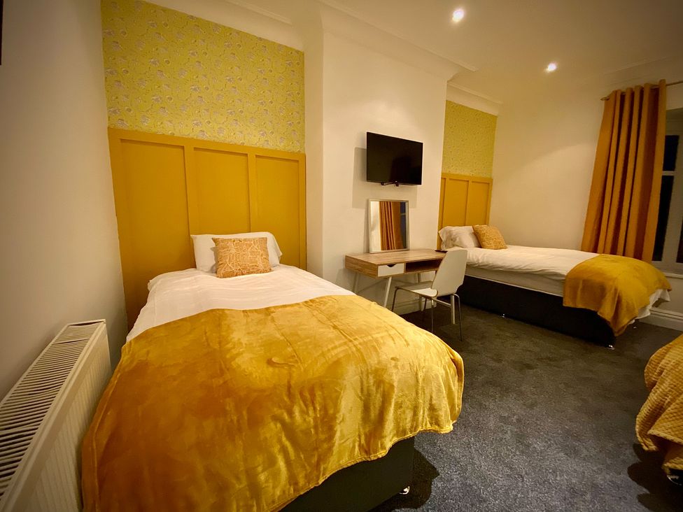 A bedroom with two single beds and a desk at 1 Horncliffe Road, Blackpool